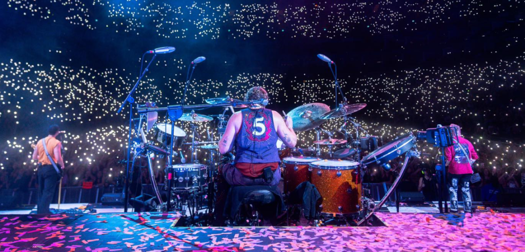 Picture of 5sos on tour. Both the members and the audience can be seen