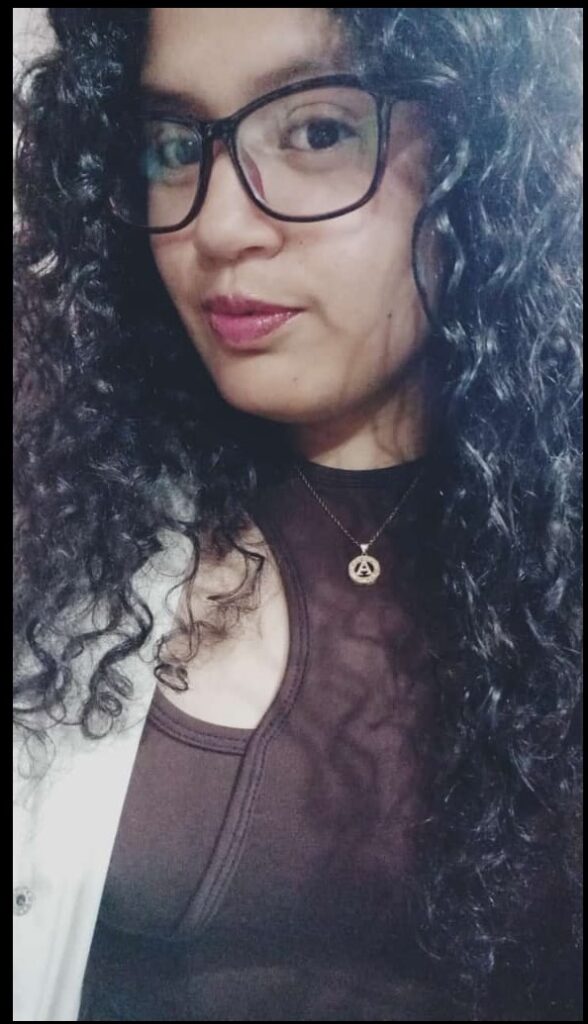 Foto de la persona de la biografía, mujer, cabello negro, usa lentes, de cabello rizado